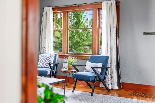 sitting room with wood finished floors and a textured wall