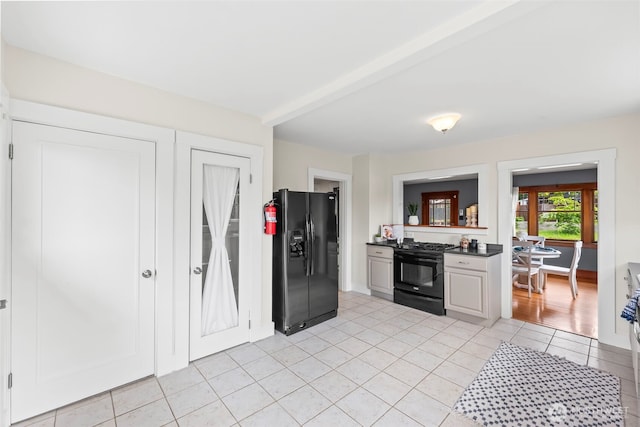 kitchen featuring dark countertops, light tile patterned floors, and black appliances