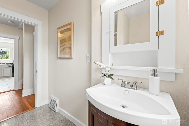 bathroom featuring vanity, baseboards, and visible vents