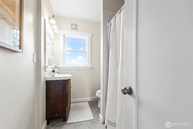 bathroom with toilet, curtained shower, baseboards, and vanity