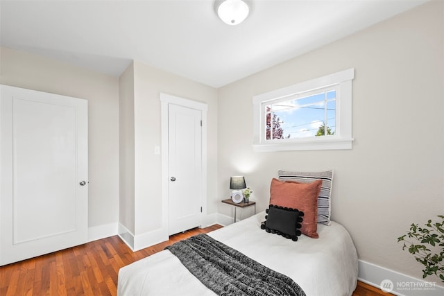 bedroom with baseboards and wood finished floors
