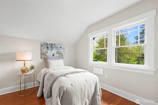 bedroom with lofted ceiling, baseboards, and wood finished floors