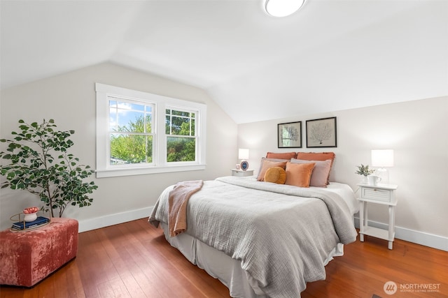 bedroom with hardwood / wood-style flooring, lofted ceiling, and baseboards