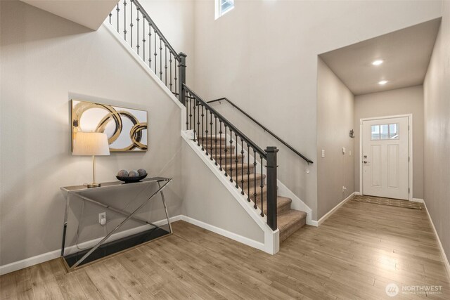 entrance foyer with wood finished floors, stairway, and baseboards