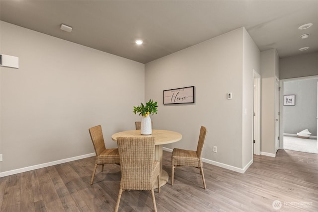 dining room featuring wood finished floors, recessed lighting, and baseboards
