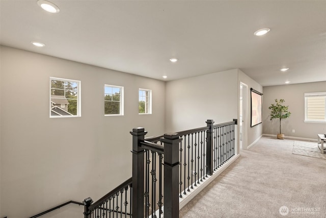 hallway with an upstairs landing, recessed lighting, carpet floors, and plenty of natural light