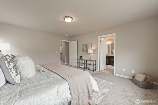 bedroom with light carpet, baseboards, and ensuite bathroom