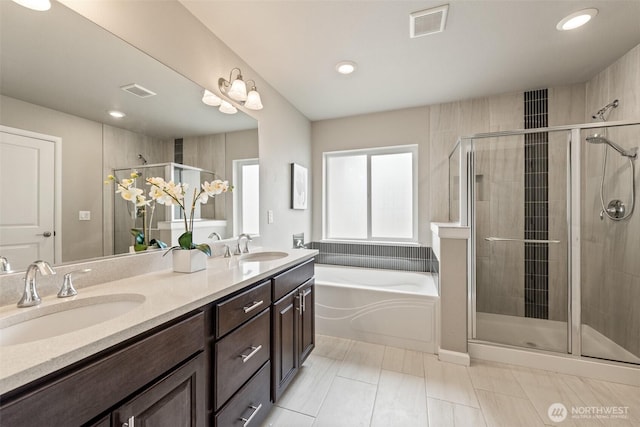 full bath featuring a shower stall, a garden tub, double vanity, and recessed lighting
