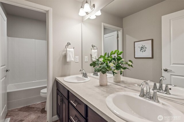 bathroom with toilet, double vanity, and shower / tub combination