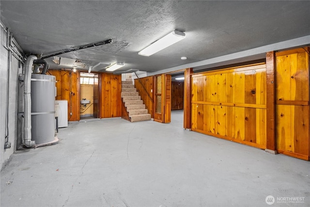 6027 S Bell St, Tacoma, WA 98408 - basement with strapped water heater, stairs, washer / clothes dryer, and a textured ceiling