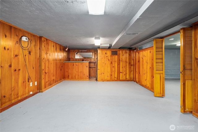 6027 S Bell St, Tacoma, WA 98408 - finished basement featuring wooden walls, a textured ceiling, and baseboards