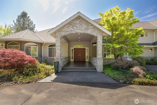entrance to property with driveway and stucco siding