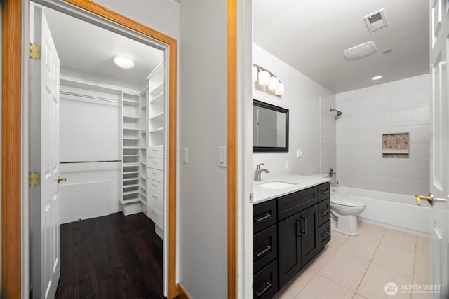 full bath with toilet,  shower combination, visible vents, vanity, and a spacious closet