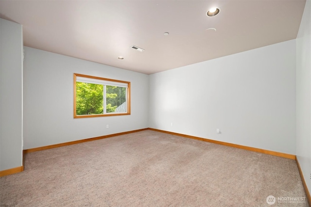 carpeted empty room with visible vents, baseboards, and recessed lighting