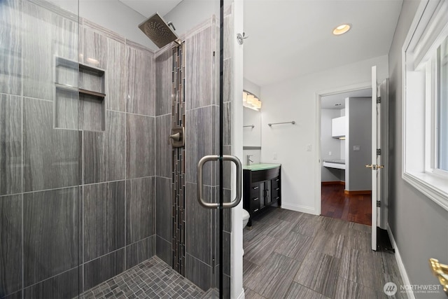 bathroom with a shower stall, vanity, recessed lighting, and wood finished floors