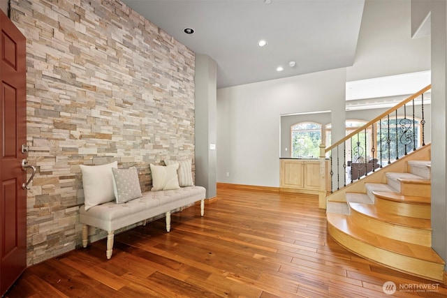 sitting room featuring a high ceiling, stairs, baseboards, hardwood / wood-style flooring, and recessed lighting