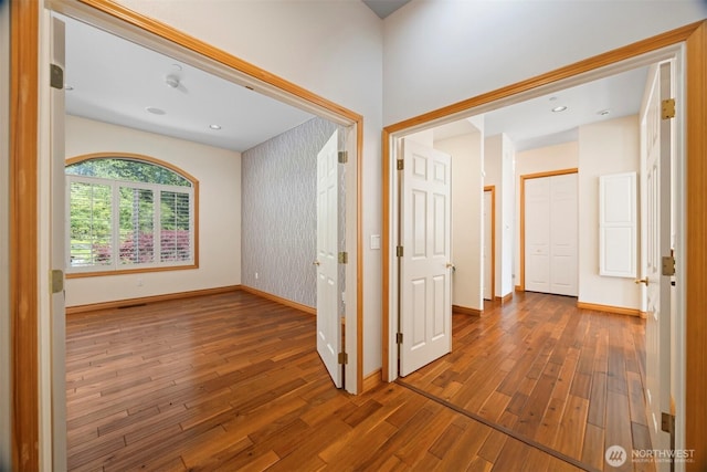 corridor featuring baseboards and wood finished floors