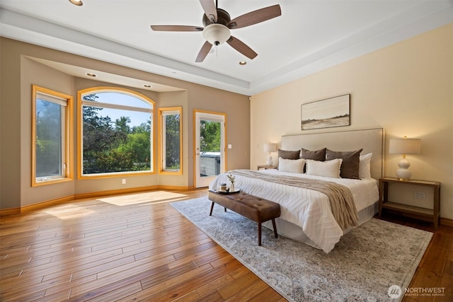 bedroom featuring baseboards, wood finished floors, recessed lighting, and access to exterior