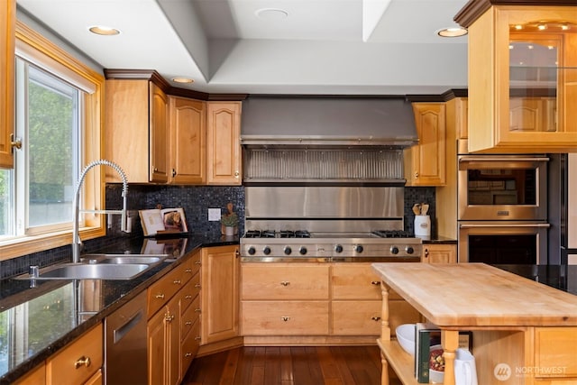 kitchen featuring a sink, stainless steel appliances, backsplash, wall chimney range hood, and butcher block counters