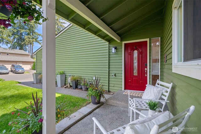 property entrance with a yard and covered porch