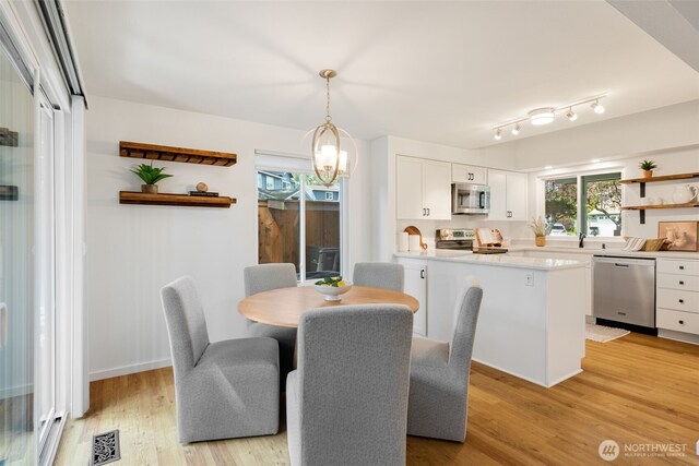 dining area with a chandelier and light wood-type flooring