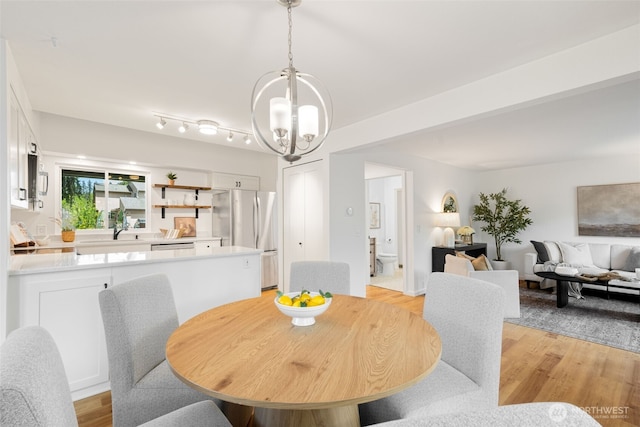 dining space with a chandelier and light wood-style flooring