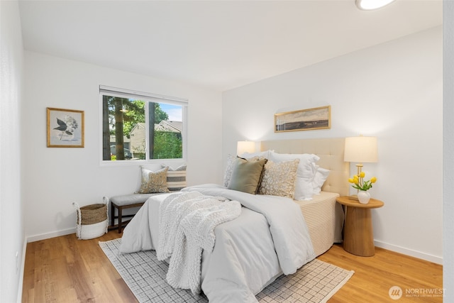 bedroom with light wood-type flooring and baseboards