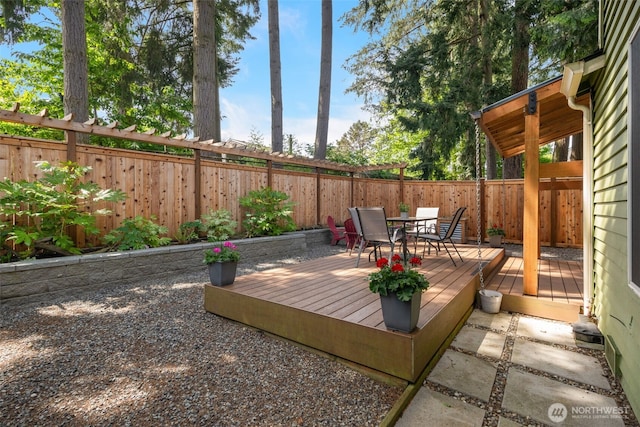 deck with outdoor dining space and a fenced backyard