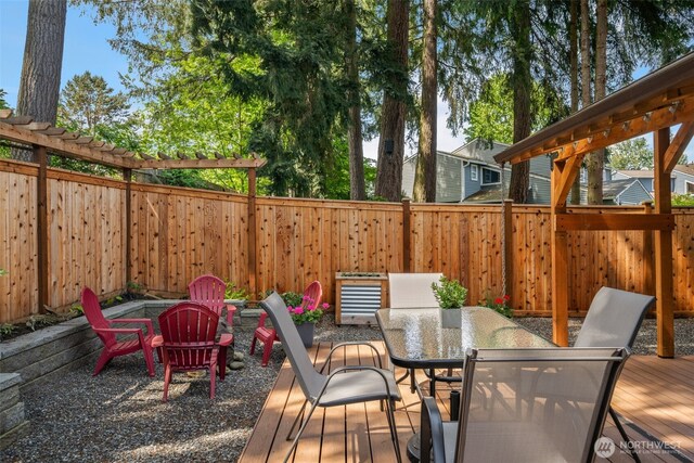deck with outdoor dining area and a fenced backyard