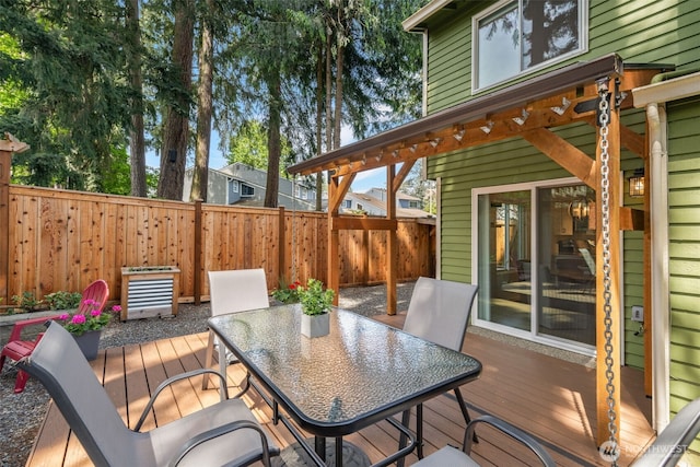 wooden terrace featuring outdoor dining area and a fenced backyard