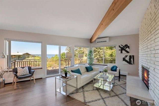 18215 3rd Pl SW, Normandy Park, WA 98166 - living area featuring a wall mounted AC, beam ceiling, wood finished floors, a brick fireplace, and baseboards