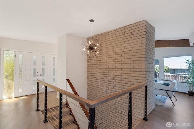18215 3rd Pl SW, Normandy Park, WA 98166 - hallway featuring a chandelier, wood finished floors, brick wall, an upstairs landing, and a wall mounted air conditioner
