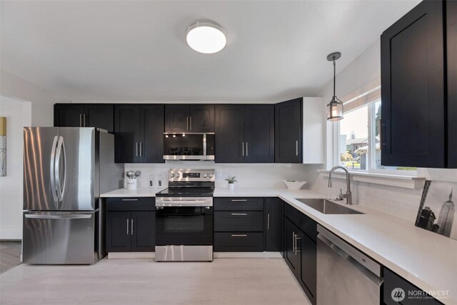 18215 3rd Pl SW, Normandy Park, WA 98166 - kitchen with appliances with stainless steel finishes, a sink, light countertops, and hanging light fixtures