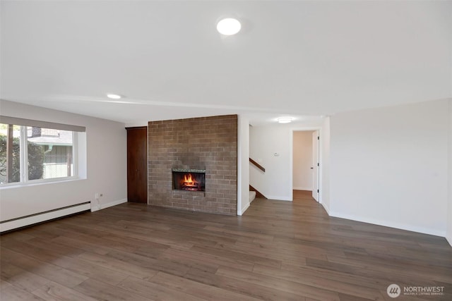 18215 3rd Pl SW, Normandy Park, WA 98166 - unfurnished living room with a brick fireplace, stairs, wood finished floors, and baseboards