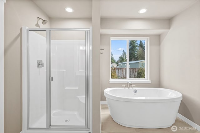 full bath featuring a shower stall, baseboards, a freestanding bath, tile patterned floors, and recessed lighting