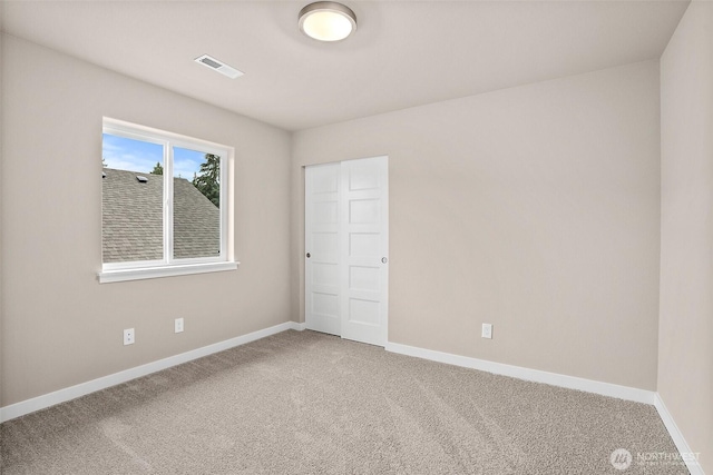 carpeted empty room featuring baseboards
