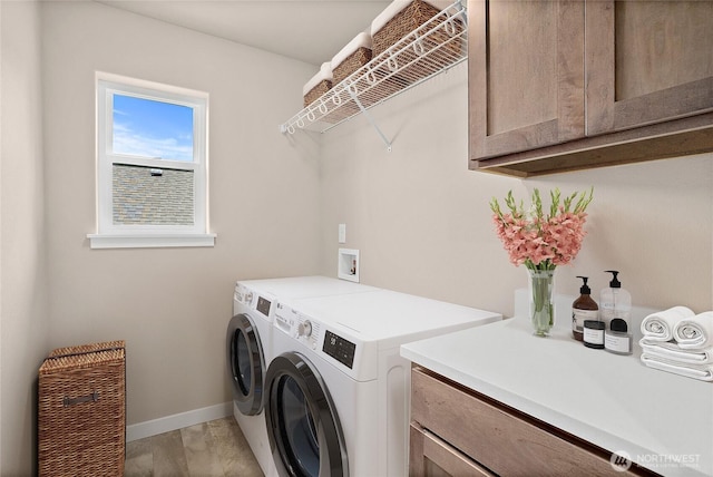 laundry area with cabinet space, washer and clothes dryer, and baseboards