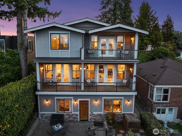 back of property featuring a balcony and french doors
