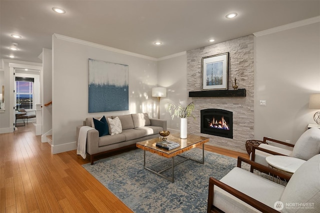 living room with a fireplace, crown molding, baseboards, wood finished floors, and recessed lighting