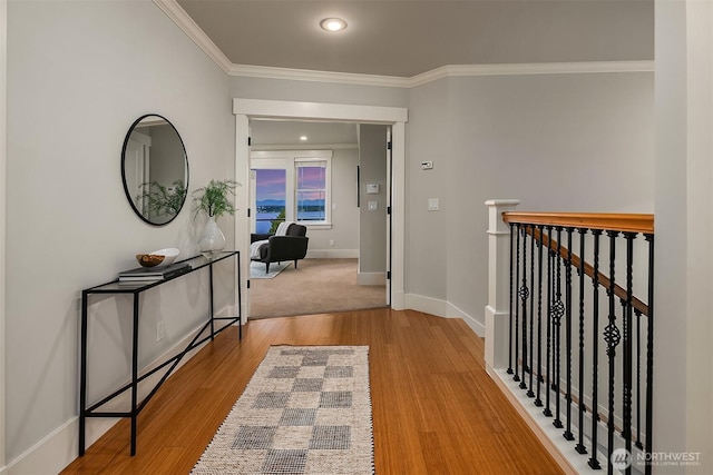 hall with crown molding, baseboards, an upstairs landing, wood finished floors, and recessed lighting