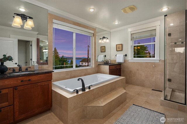 bathroom featuring crown molding, a bath, tile patterned floors, two vanities, and a tile shower