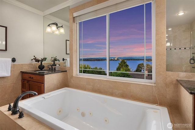 bathroom featuring tile walls, a water view, vanity, crown molding, and a tub with jets