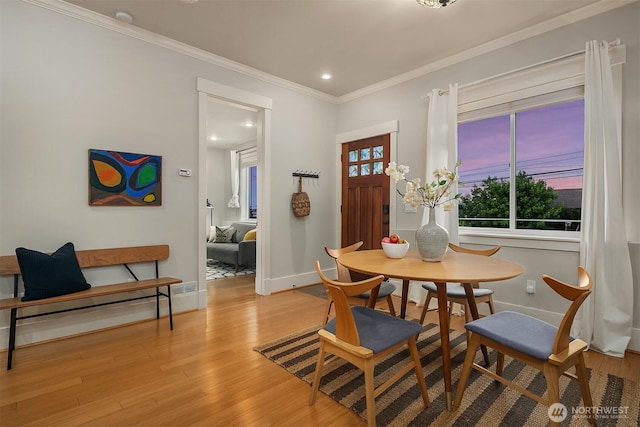 dining area with baseboards, light wood-style floors, ornamental molding, and recessed lighting