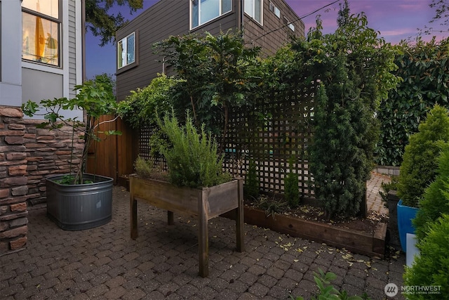 patio terrace at dusk featuring fence