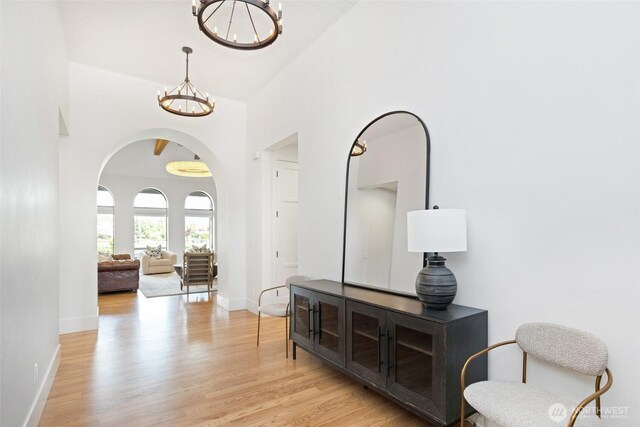 1502 Ironwood Dr, Walla Walla, WA 99362 - entrance foyer with arched walkways, baseboards, light wood finished floors, and a chandelier