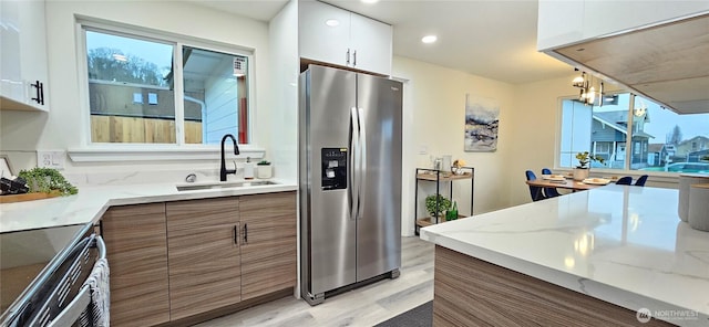 1442 E 31st St, Tacoma, WA 98404 - kitchen with a sink, light wood-style floors, stainless steel appliances, and a wealth of natural light