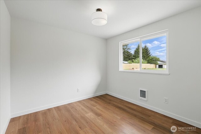 empty room with light wood finished floors and baseboards