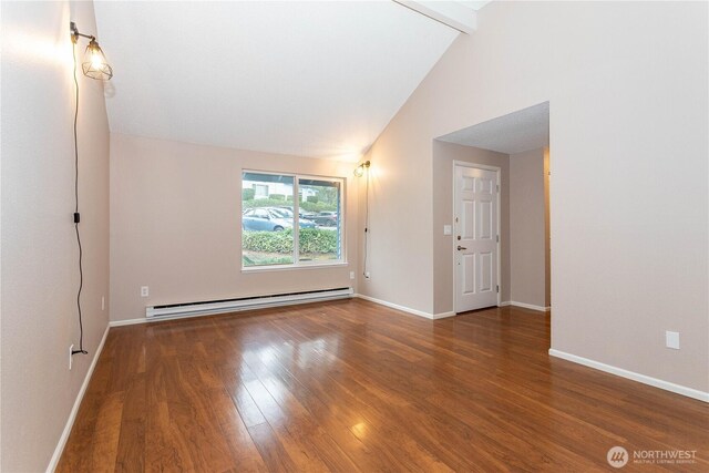 spare room featuring baseboards, baseboard heating, wood finished floors, and vaulted ceiling