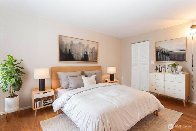 bedroom featuring a closet, wood finished floors, and baseboards