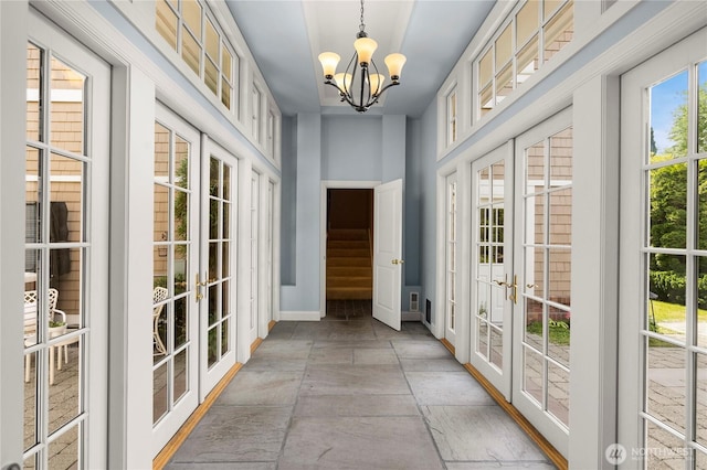 2530 39th Ave E, Seattle, WA 98112 - doorway with french doors, a chandelier, stone tile floors, and baseboards